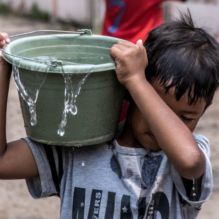 A boy carries water